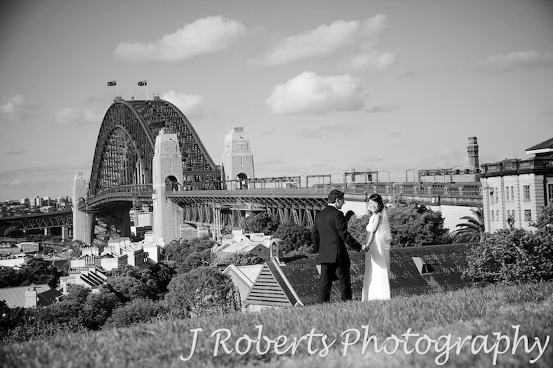 Bride and groom looking back over shoulder while walking down observatory sydney - wedding photography sydney